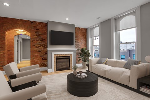 A living room with a fireplace and a flat screen TV mounted on the wall.at The Granite Works Apartments , Buffalo